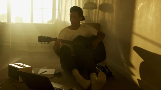 Creator sitting inside a softly lit apartment with calm editorial atmosphere