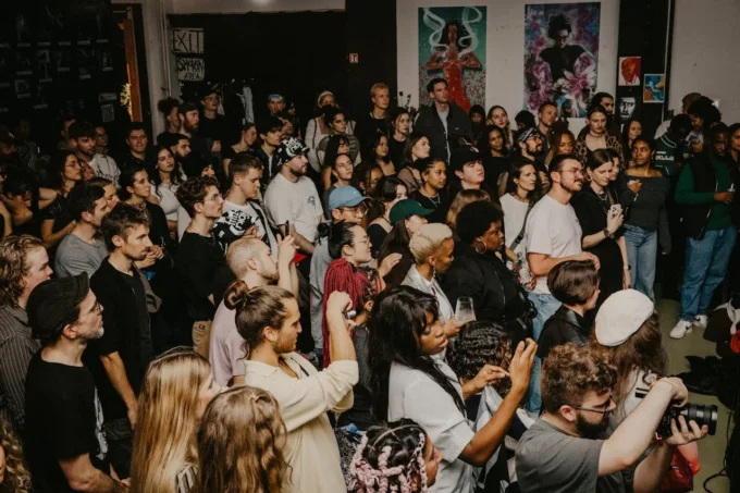 Crowd waiting outside a fashion week venue with photographers and street style attendees