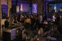 Fashion and music event inside a modern industrial rooftop venue with DJs, stylish guests, and relaxed creative atmosphere.