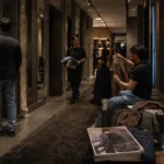 Luxury fashion store fitting room corridor with shoppers trying on clothing in a warm cinematic retail environment.